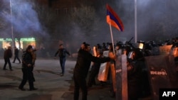 Armenia -- A man is holding an Armenian flag up as protesters clash with police during a demonstration near the Russian Consulate in Gyumri, January 15, 2015