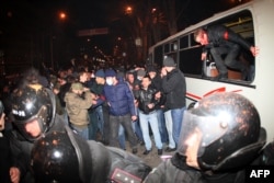 Учасници Самооборони вибираються з оточеного проросійськими активістами автобуса через вікна. Донецьк, 13 березня 2014 року