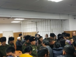 Сапар Исаков темир тордун ичинен кол булгалап жатат. 6-декабрь, 2019-жыл.