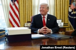 Президент Дональд Трамп в Овальном кабинете перед подписанием закона о сокращении налогов. 22 декабря 2017 года
