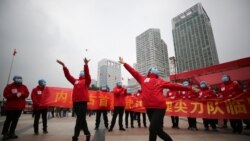 کارکنان بیمارستانی موقت در ووهان در پی مرخص شدن همه بیماران جشن گرفتند، ۹ مارس ۲۰۲۰