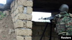 Azerbaijan -- An Azeri serviceman aims his weapon at the frontline with the self-defense army of Nagorno-Karabakh in Azerbaijan, April 29, 2016