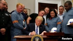 Президент Дональд Трамп болот менен алюминийге бажы салыгын киргизүүчү чечимге кол коюп жатат. Вашингтон, 8-март, 2018-жыл.