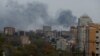Smoke rises above buildings after a warehouse was hit by Russian shelling in Donetsk, Russian-controlled Ukraine, on October 21.