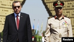 Müsüriň goşun serkerdebaşysy general Hassan al-Roweny Türkiýäniň premýer-ministri Rejep Taýýip Erdogany Kairde garşy alýar. 13-nji sentýabr, 2011.