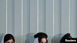 دختران مدرسه ای در حال گوش فرا دادن به سخنرانی حامد کرزای، رییس جمهور افغانستان