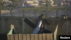 Osama bin Ladeniň öldürilen ýerinde parçalanan dikuçaryň bir bölegi ýatyr, 2011-nji ýylyň 2-nji maýy.