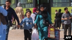 یک اتوبوس ایرانی پناهجویان افغانستانی را در مرز اسلام‌قلعه در ولایت هرات پیاده می‌کند