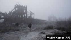 Український солдат іде крізь туманповз зруйновану вугільну шахту, наближаючись до лінії фронту в Авдіївці, 19 листопада