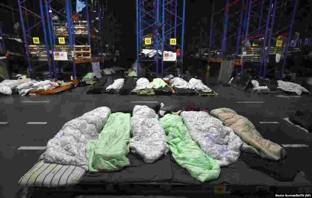 Migrants sleep in a logistics center in Belarus near the Kuznica border crossing. In an interview with the BBC on November 19, Lukashenka acknowledged that it is &quot;absolutely possible&quot; that his security forces had assisted migrants but denied that his government had brought them to Belarus.