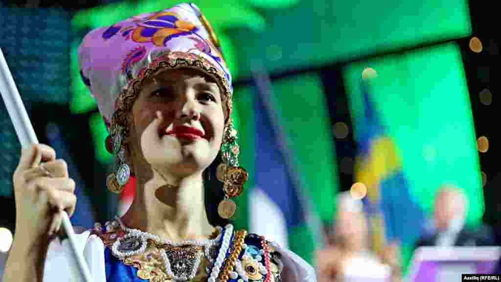 Фестивальдә катнашучы илнең әләмен тотучы кыз