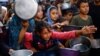Palestinians gather to receive food from a charity kitchen, in Nuseirat