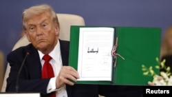 Президент США Дональд Трамп із підписаною угодою щодо припинення війни в Секторі Гази, саміт світових лідерів у Шарм-еш-Шейху, Єгипет, 13 жовтня 2025 року