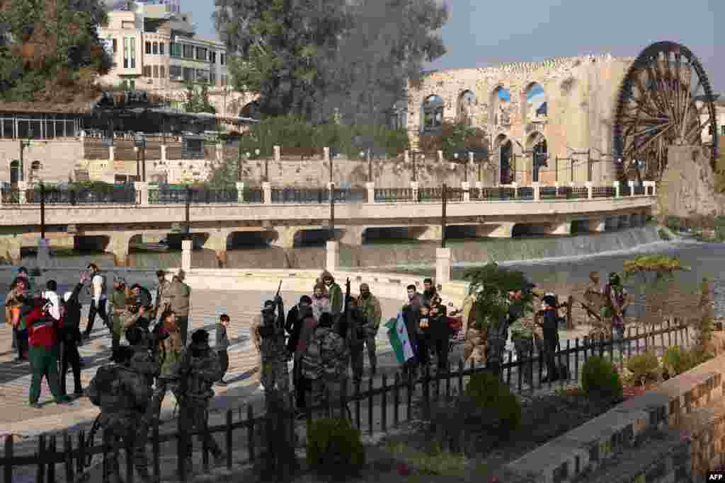 شورشیان ضد حکومت سوریه در میان غیرنظامیان نزدیک یکی از آسیاب&zwnj;های آبی حماه.