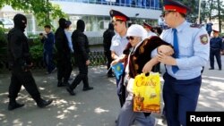 Полицейские задерживают женщину недалеко от  площади Республики в Алматы. 21 мая 2016 года. 