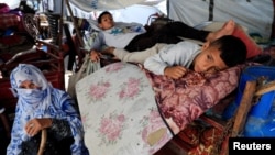 یک خانوادۀ آوارۀ فلسطینی در مدرسه‌ای وابسته به آژانس امداد سازمان ملل در خان‌یونس، ۷ خرداد