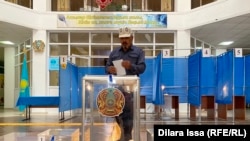 Мужчина опускает бюллетень в урну на избирательном участке в городе Шымкенте. 5 июня 2022 года