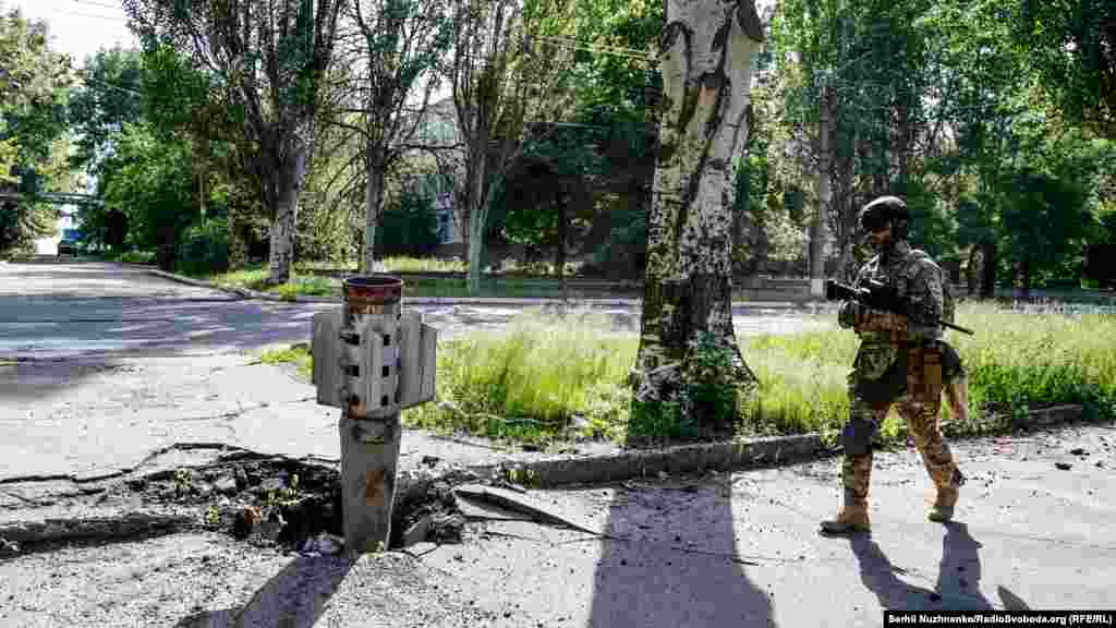 Український військовий проходить повз хвостовик від радянської ракети &laquo;Смерч&raquo;, якими російська армія обстрілює Лисичанськ