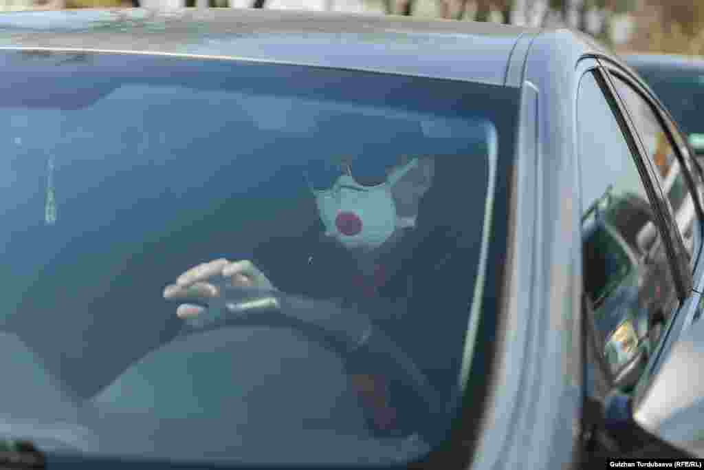 Коргонуучу бет кап кийген айдоочу.&nbsp;