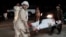 Men carry a wounded man on a stretcher outside a hospital following a car bomb in Lashkar Gah on March 23.