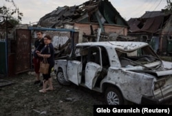 Місцеві жителі біля будинку, зруйнованого внаслідок російського ракетного удару, Покровськ, 15 червня 2022 року