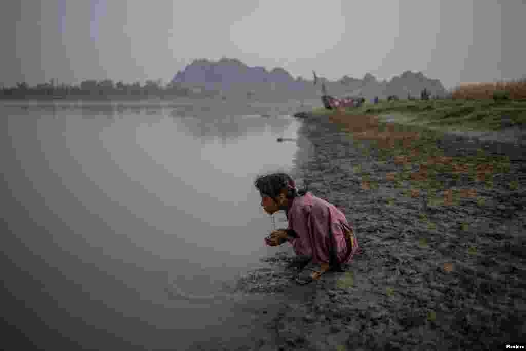 Пакистандык кыз Пенжаб провинциясындагы Чиниот шаарындагы Ченаб дарыясынын жээгинде бетин жууп жатат.
