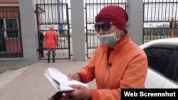 Жительница Кызылорды Акжан Ногаева читает стихи у здания акимата Кызылординской области. Кызылорда, 1 апреля 2020 года.