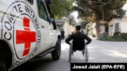 An Afghan man passes a van owned by the Red Cross in Kabul in October 2017.