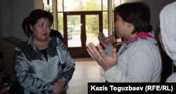 Назгуль Смагулова (слева), начальник отдела социальной сферы акимата Турксибского района Алматы, говорит с погорельцами.