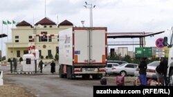 Türkmenistanyň serhet geçelgeleriniň birindäki ýolagçylar we ýük ulagy (Illýustrasiýa suraty)