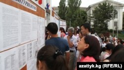 Сүрөттө Бишкектеги ЖОЖдун биринин эшигинин астында турган абитуриенттер.
