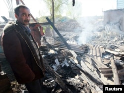 Житель Маевки у руин дома, сожженного во время конфликта в апреле 2010г.