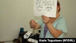 Белсенді Фемиданың суреті бейнеленген таразыны ұстап тұр. Алматы, 27 тамыз 2014 жыл.     