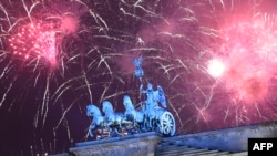 Adamlar giçlik Berliniň Brandenburg derwezesine ýygnandylar we açyk howada guralan konserte tomaşa etdiler.