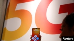 An employee displays a Huawei 5G Smartphone Mate 20X smartphone