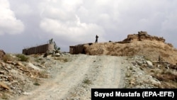 An Afghan soldier stands guard as soldiers prepare for an operation to recapture a military base from the Taliban in Ghazni Province on May 2.