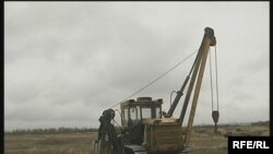 Сарандағы ұрылар құбырды қопарып, тарктормен тиеп алып кете береді. Саран, қараша, 2008 жыл