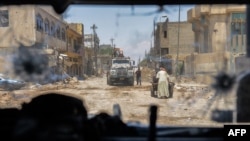 تصویری از داخل یک خودروی زرهی ارتش عراق باقی‌مانده‌هایی از شهر قدیم موصل را نشان می‌دهد