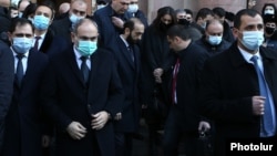 Armenian Prime Minister Nikol Pashinian (second from left) emerges from the main government building in Yerevan to lead a procession to the Erablur Military Pantheon on December 19.
