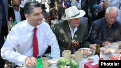 Armenia -- Prime Minister Tigran Sarkisian (L) shares meal with World War II veterans in Yerevan's Victory Park, 9May2012.