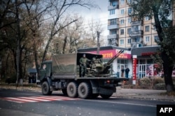 A military truck carries an antiaircraft gun through the streets of Donetsk on November 2.