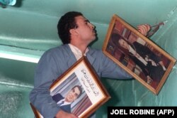 یک شهروند تونسی در حال جابه‌جا کردن عکس‌های بورقیبه و بن‌علی پس از آنکه بن‌علی قدرت را به دست گرفت