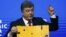 Президент Петро Порошенко демонструє на міжнародному форумі в Давосі уламок цивільного автобуса, знищеного російською ракетою у Волновасі (21 січня 2015 року)
