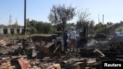 Мешканці стоять на місці будівлі, зруйнованої російськими військовими у селі Ямпіль, Сумська область, Україна, 6 вересня 2024 року. Фото ілюстративне