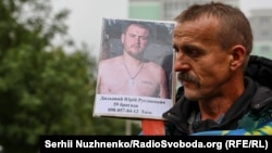 Батько з фотографією зниклого безвісти сина на обміні від 2 жовтня 2025 року 