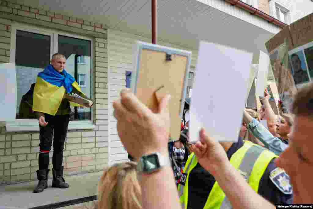 Звільнений український військовополонений розмовляє із родичами інших полонених, які досі перебувають у полоні