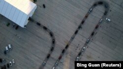 АКШдагы COVID-19 сынагынан өтүү жайындагы автоунаалар кезеги. Милуоки, Висконсин штаты. 2020-жылдын 5-ноябры (дрон аркылуу тартылган көрүнүш). 