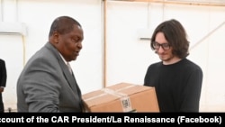 На фотографії, розміщеній на сторінці президента ЦАР у Facebook, Дмитро Ситий (праворуч) передає ящики з медикаментами президенту Фостен-Аршанж Туадера в лютому 2025 року