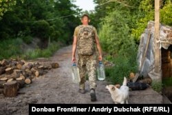 Український військовий несе воду на бойові позиції переднього краю під Новотроїцьким, Донецька область, 22 чернвя 2021 року