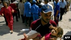 یک عراقی در حال بردن دختر مجروح خود به بیمارستانی در کرکوک در روز شنبه